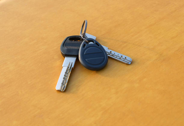 a pair of metal key on a wooden orangey surface