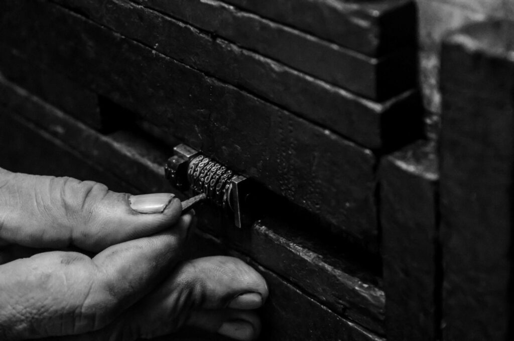 black and white photo of a person's hand picking a lock