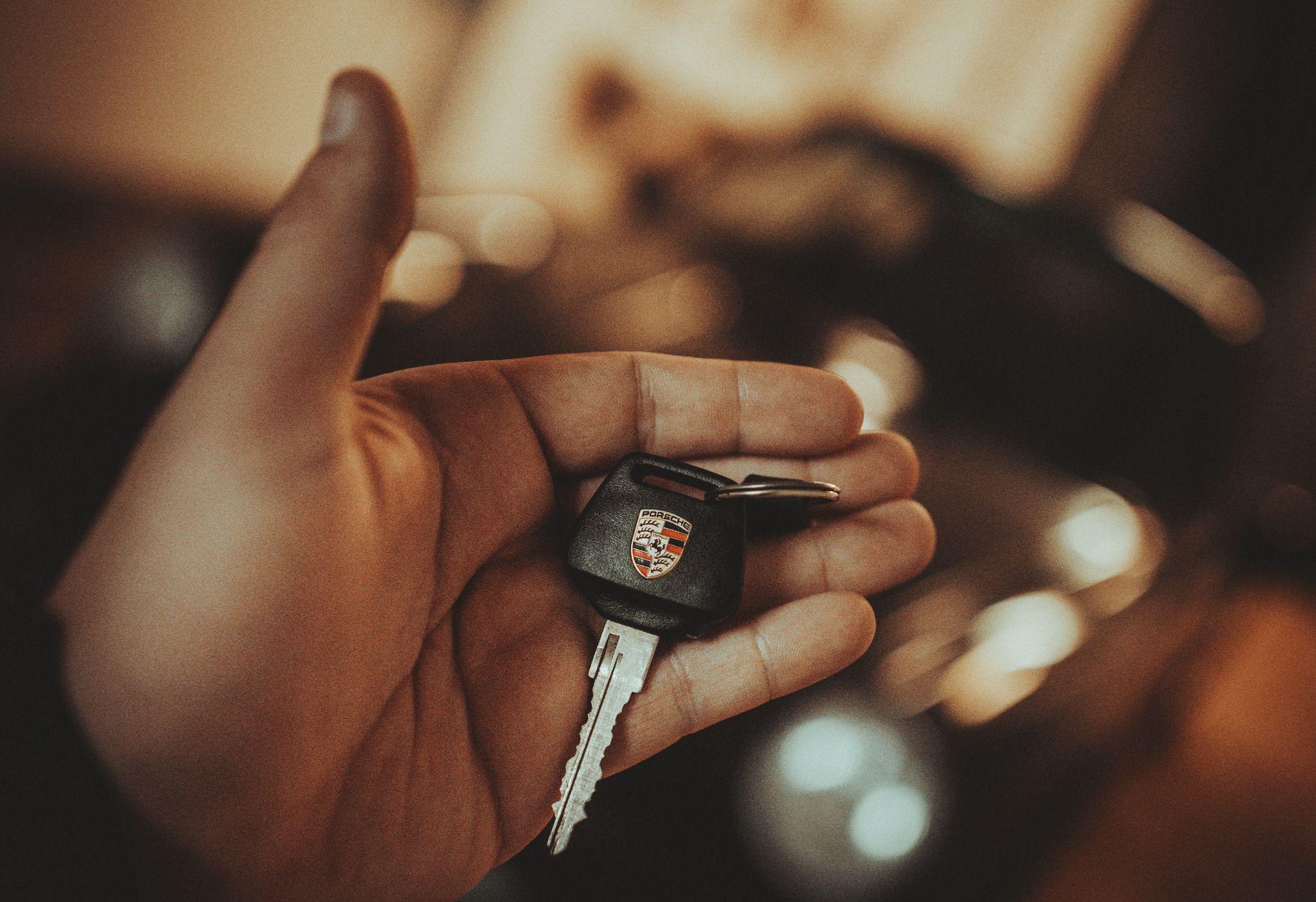 a porsche car key on a man's hand